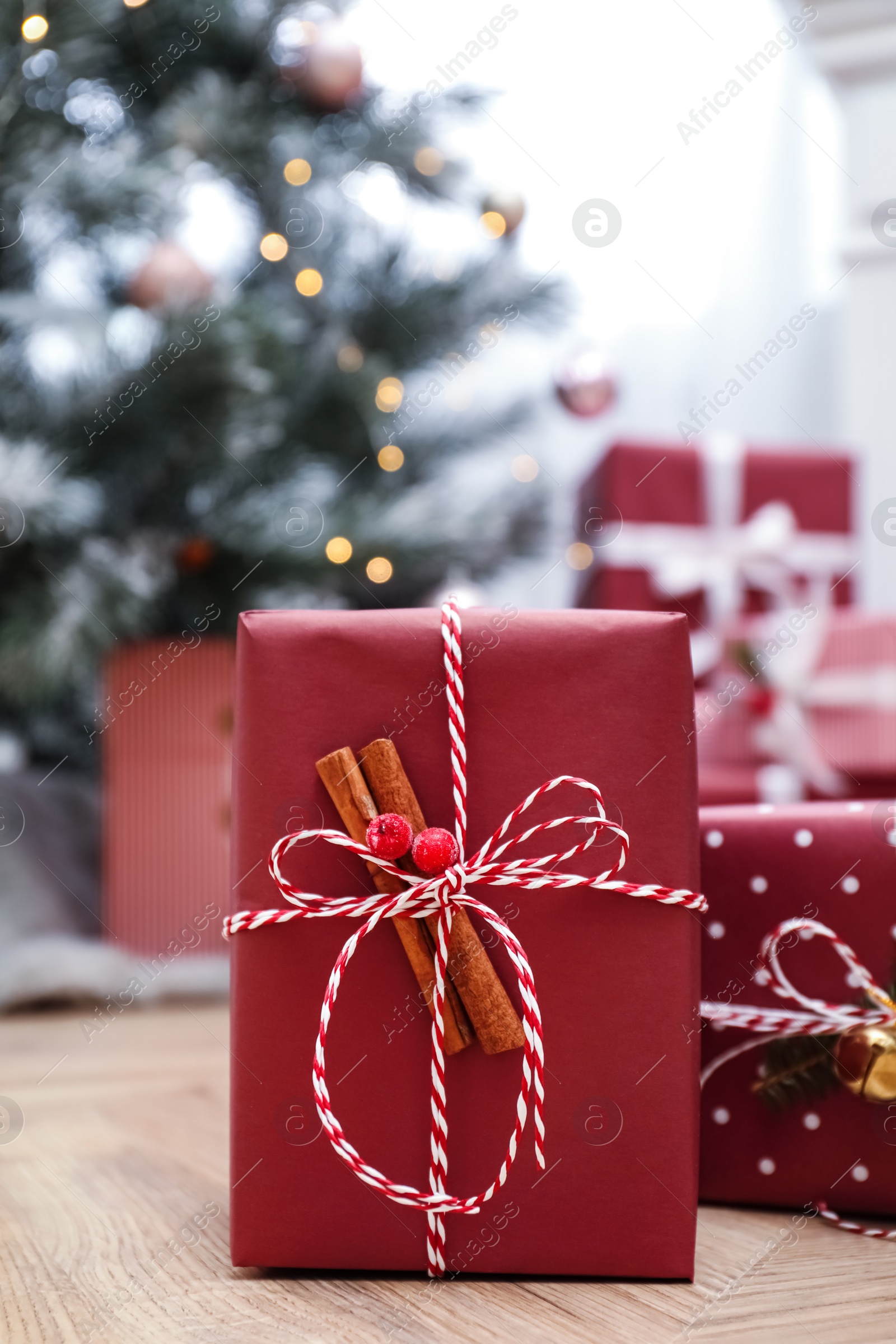 Photo of Beautiful gifts and blurred Christmas tree on background. Space for text
