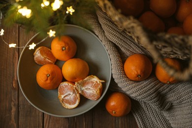 Photo of Fresh ripe tangerines and Christmas decor on wooden table, flat lay