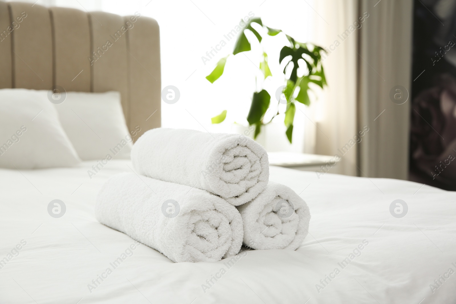 Photo of Clean white towels on bed at home