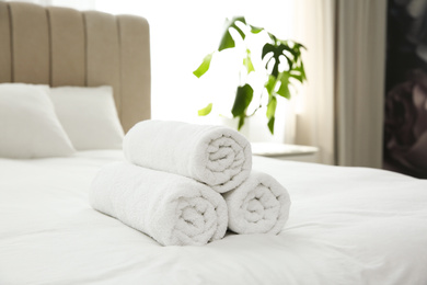 Photo of Clean white towels on bed at home