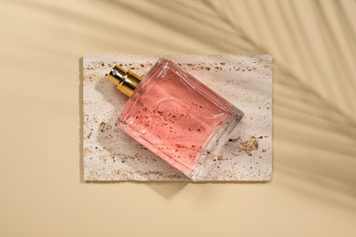 Photo of Luxury women's perfume in bottle on beige background, top view