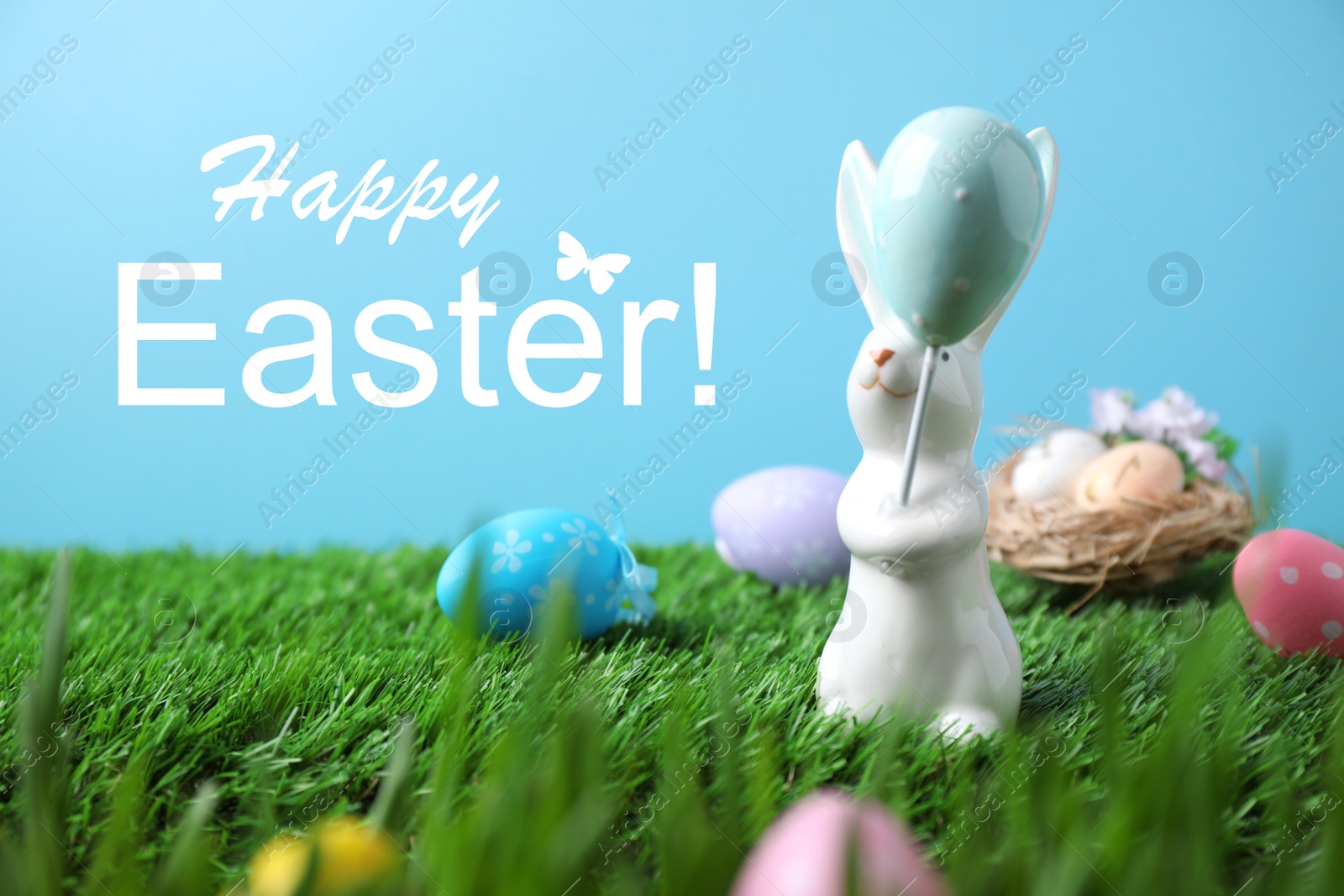 Image of Easter bunny figure and painted eggs on green grass