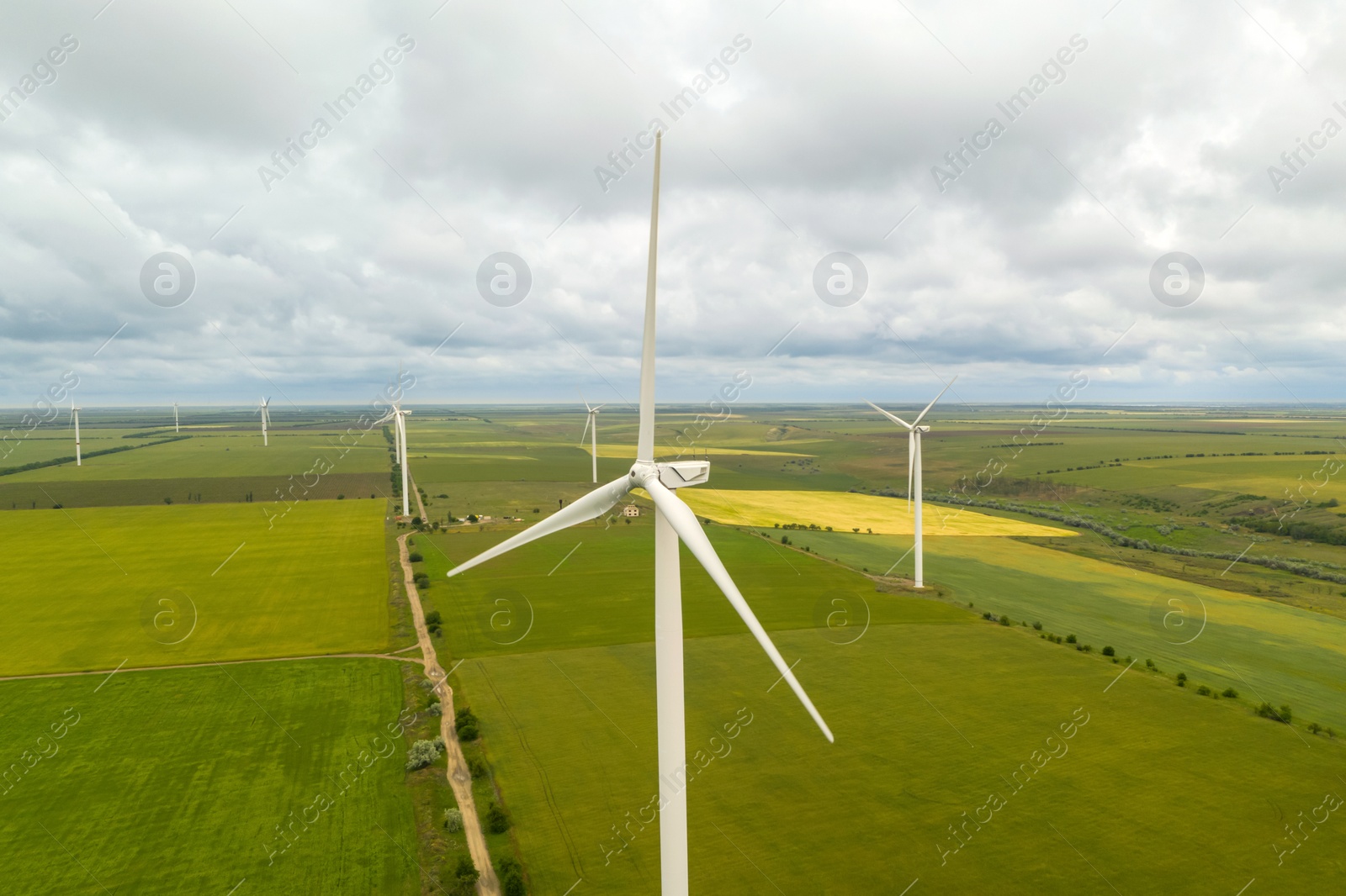 Image of Aerial view of wind turbines in field on cloudy day