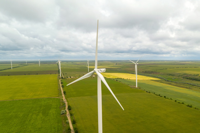 Image of Aerial view of wind turbines in field on cloudy day