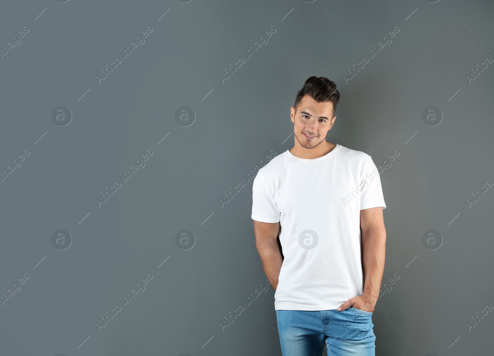 Photo of Young man in t-shirt on grey background. Mockup for design