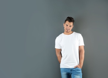 Young man in t-shirt on grey background. Mockup for design