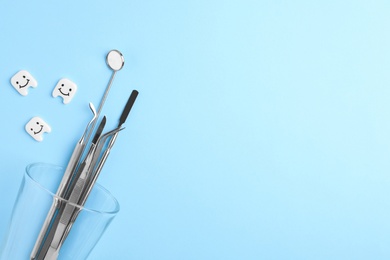 Photo of Flat lay composition with dentist tools and decorative teeth on color background. Space for text