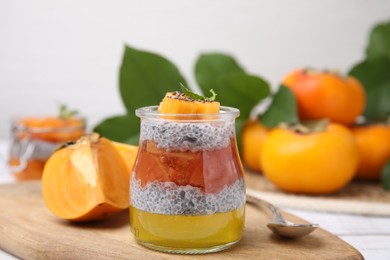 Photo of Delicious dessert with persimmon and chia seeds on table