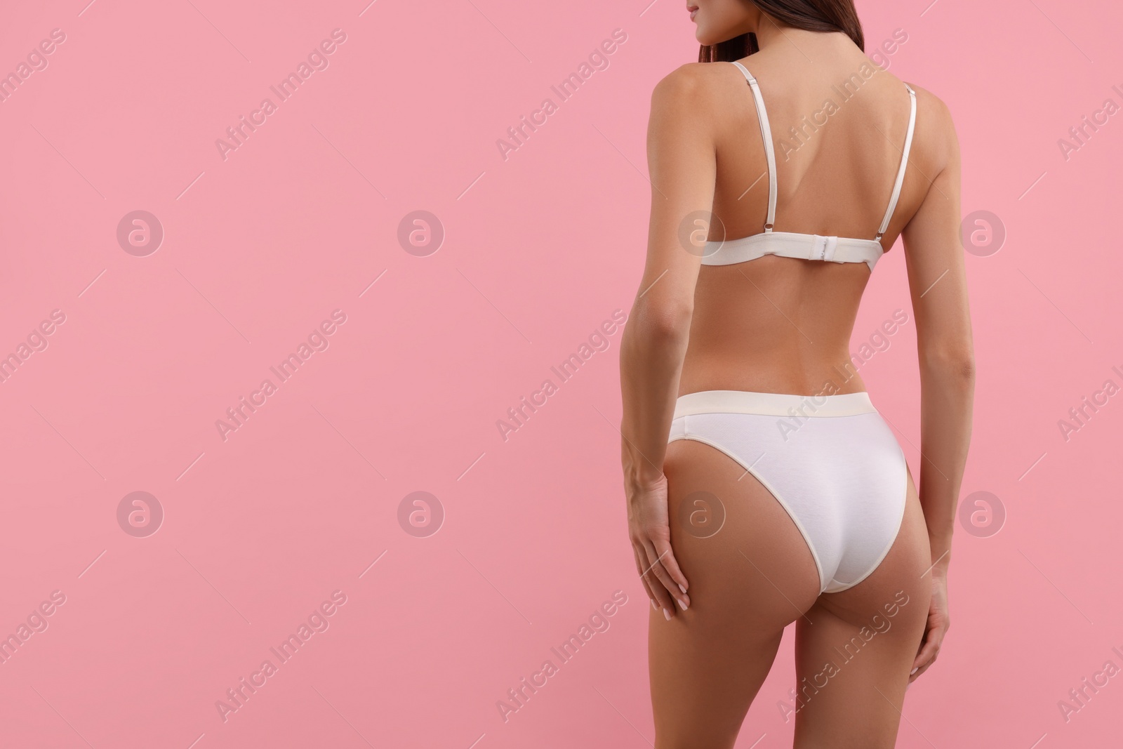 Photo of Young woman in stylish white bikini on pink background, closeup. Space for text