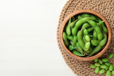 Photo of Green edamame beans on white wooden table, flat lay. Space for text