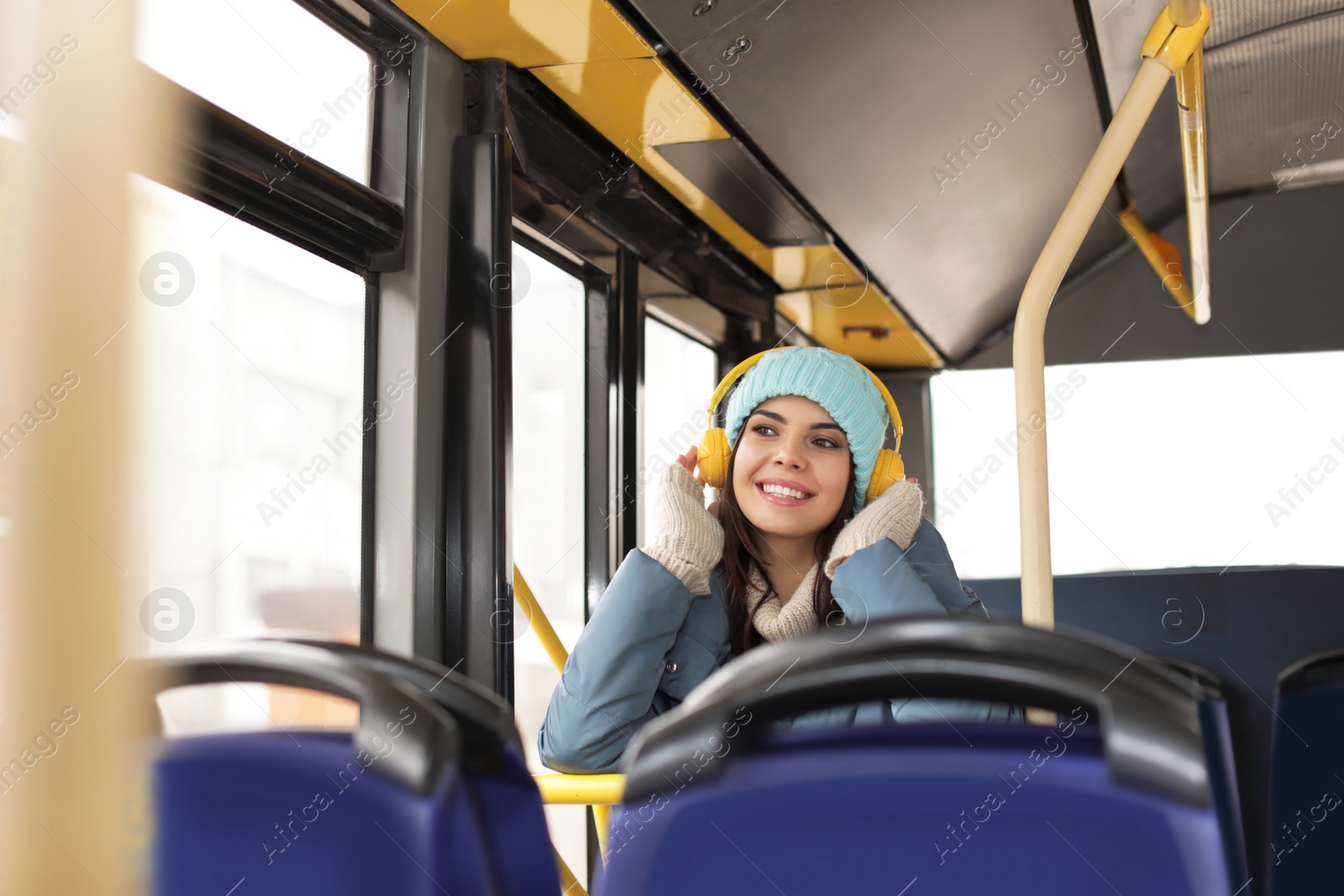 Photo of Young woman listening to music with headphones in public transport