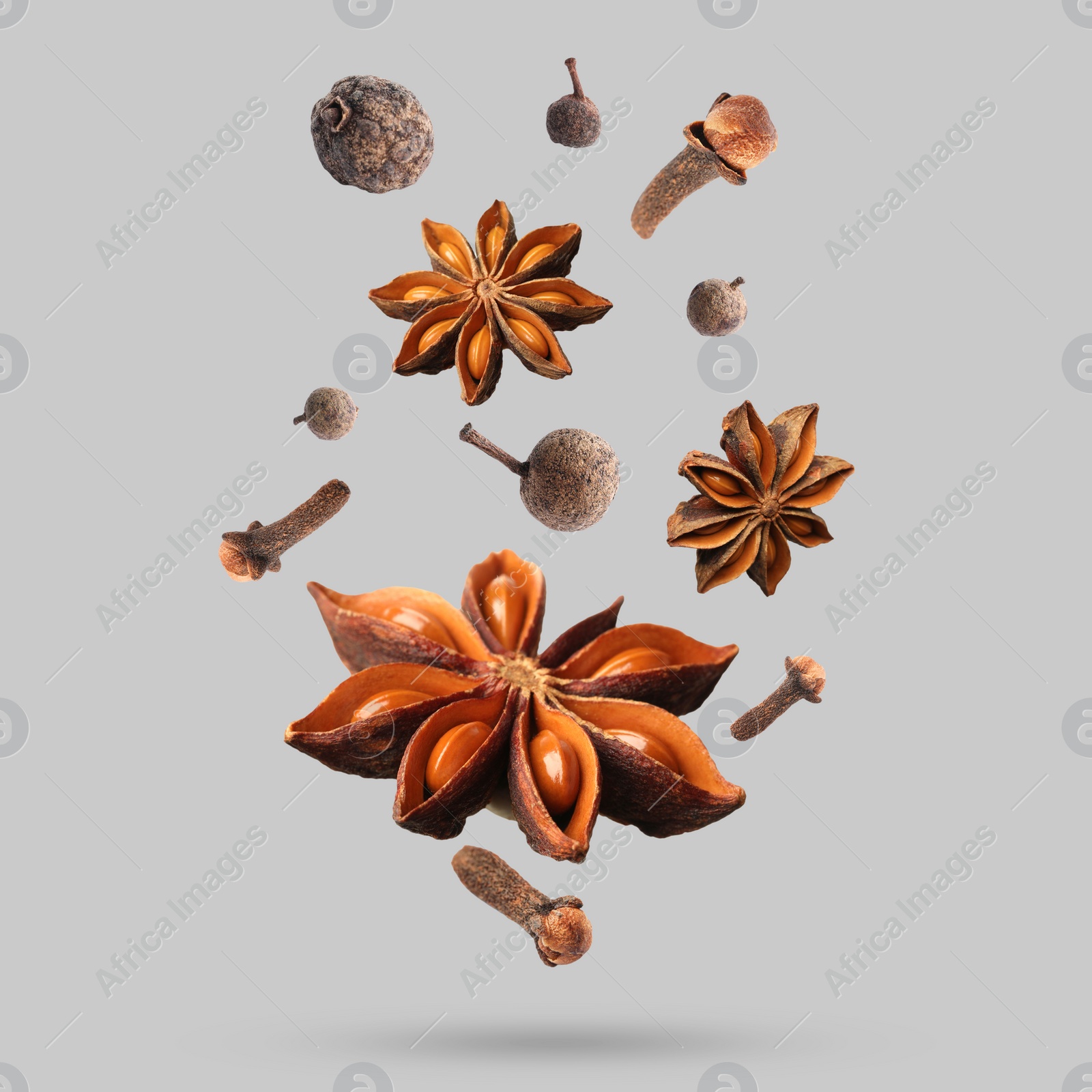 Image of Different spices falling on light grey background