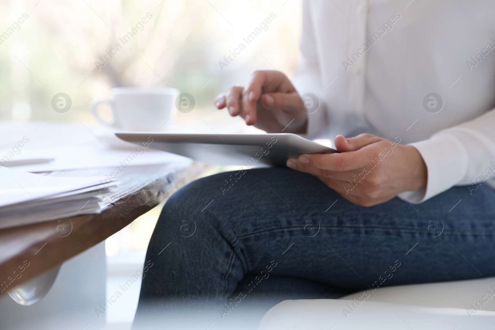 Photo of Businesswoman working with modern tablet in office, closeup