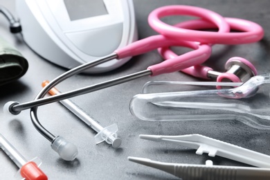 Photo of Stethoscope and other medical objects on grey table