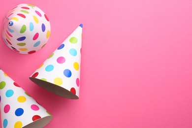 Beautiful party hats on pink background, top view. Space for text