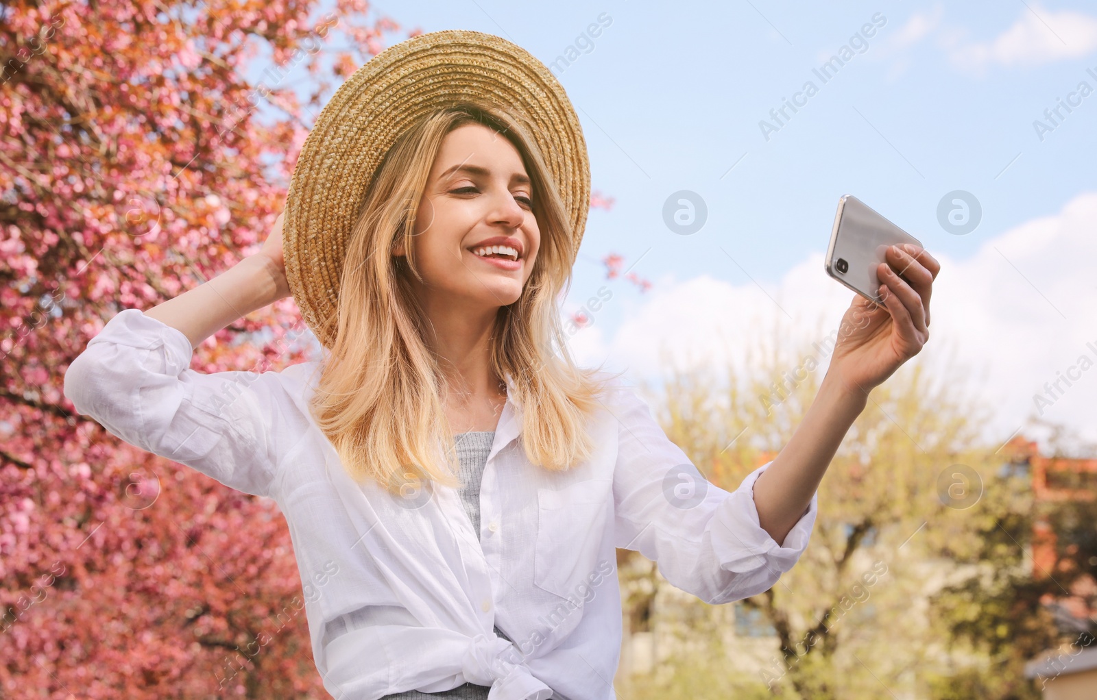 Photo of Happy woman taking selfie outdoors on spring day