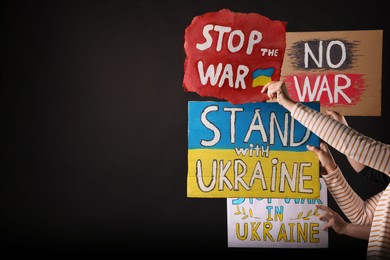 Photo of Stop war in Ukraine. People holding posters on black background, space for text