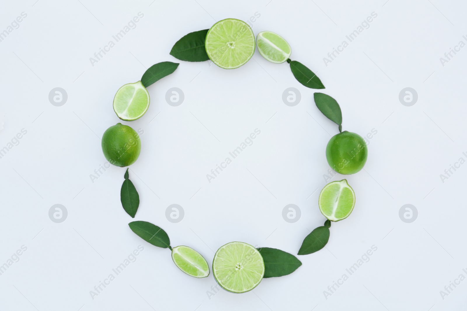 Photo of Frame made of fresh ripe limes and green leaves on white background, flat lay. Space for text