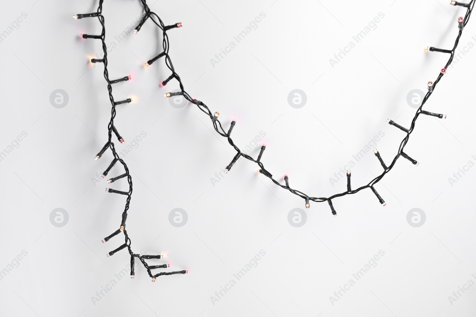 Photo of Beautiful Christmas lights on white background, top view