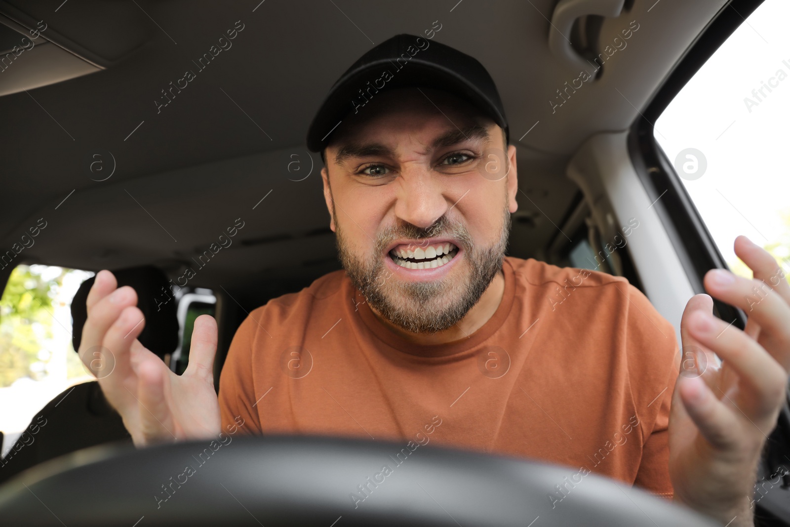 Photo of Emotional man in car. Aggressive driving behavior