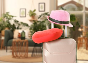 Image of Travel pillow and hat on suitcase in room. Space for text