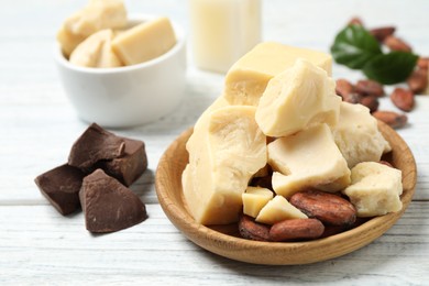 Photo of Composition with organic cocoa butter on white wooden table, closeup