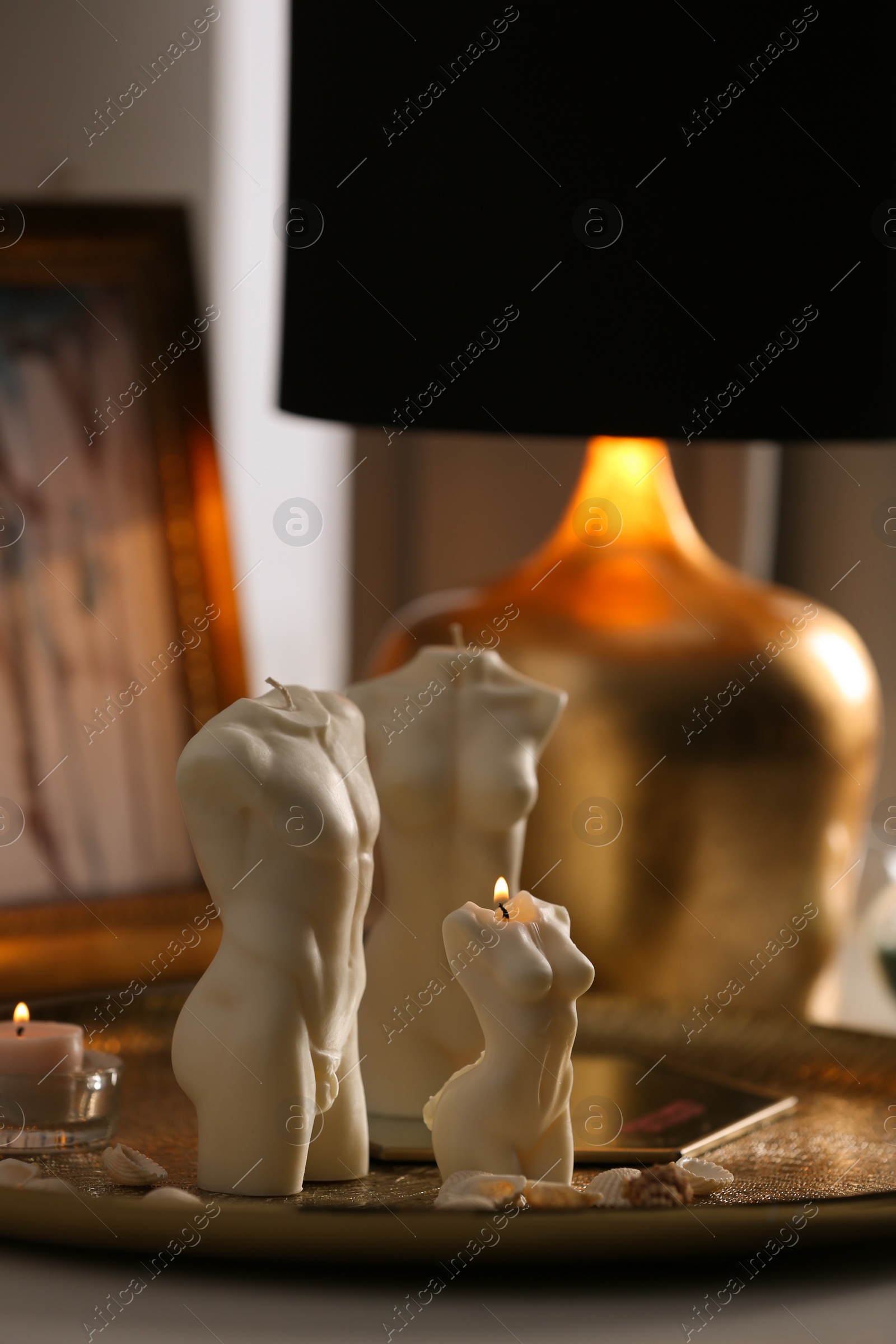 Photo of Beautiful body shaped candles on table indoors