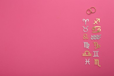 Photo of Zodiac compatibility. Signs with wedding rings on pink background, flat lay. Space for text