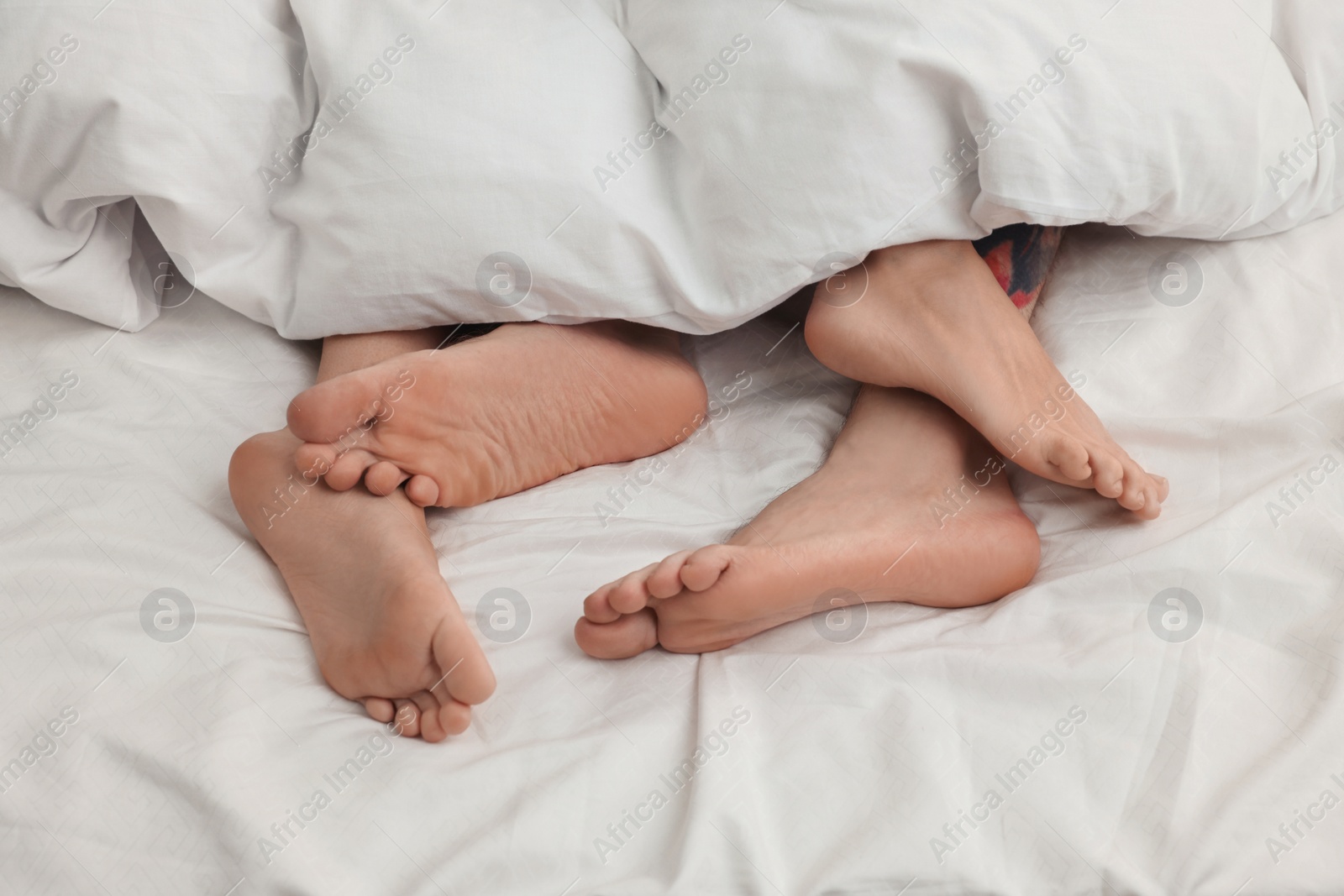 Photo of Passionate couple having sex on bed, closeup of legs