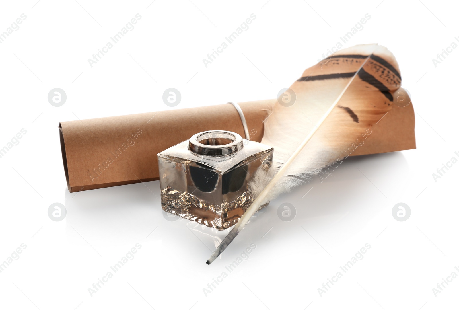 Photo of Feather pen with inkwell and paper scroll on white background