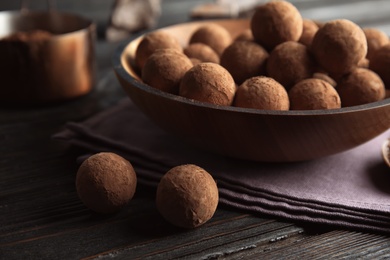 Plate and chocolate truffles on wooden background