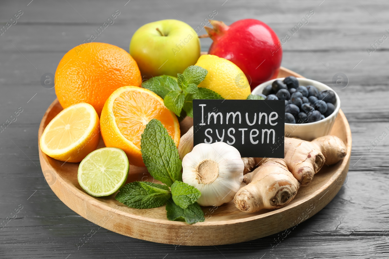 Photo of Card with phrase Immune System and fresh products on grey wooden table