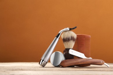 Moustache and beard styling tools on wooden table. Space for text