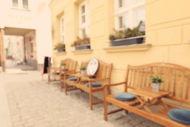 Photo of Blurred view of outdoor cafe with wooden benches