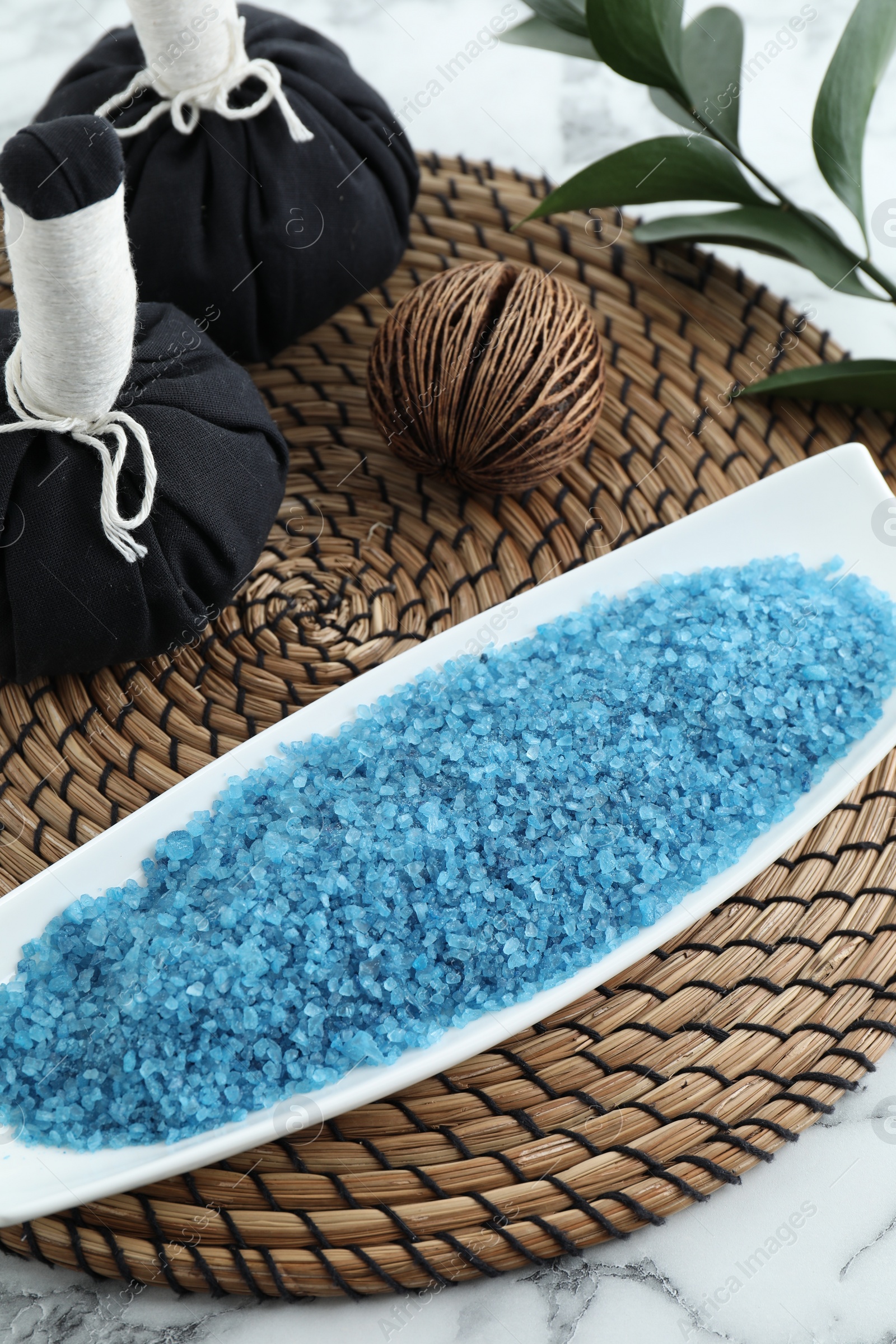 Photo of Composition with blue sea salt and herbal bags on white marble table