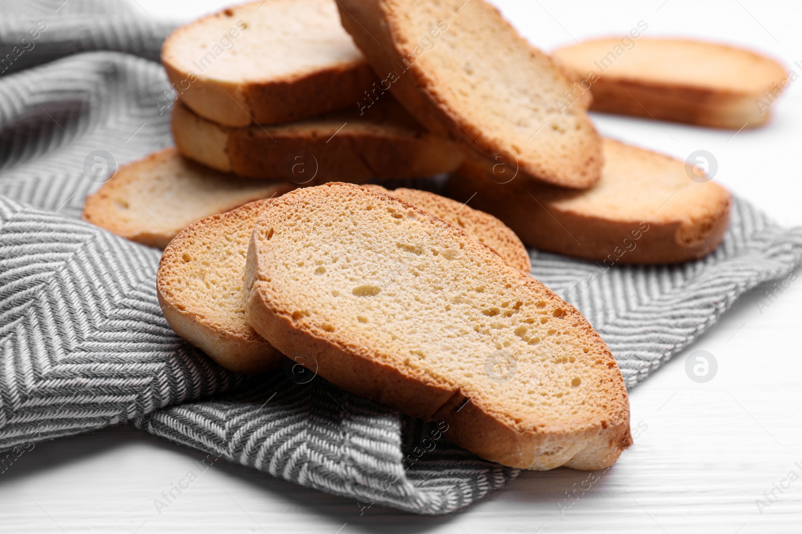 Photo of Tasty hard chuck crackers on white wooden table, closeup