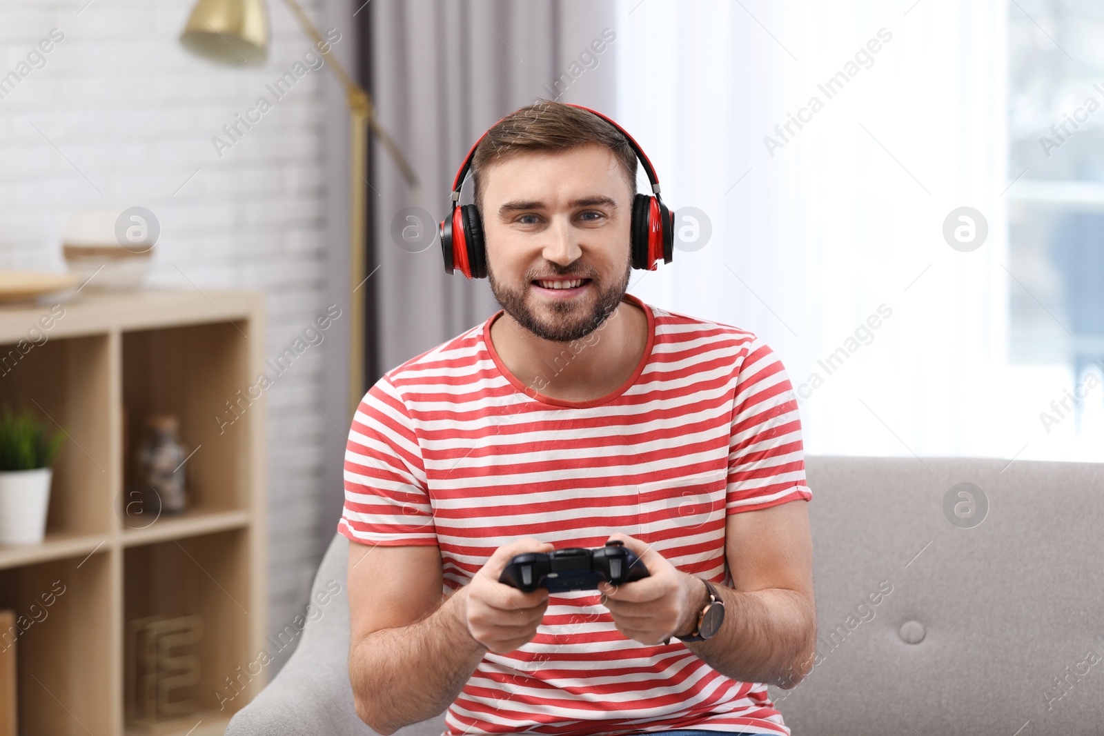 Photo of Young man playing video game at home