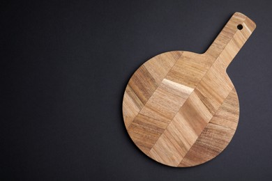 Photo of One wooden board on black background, top view. Space for text
