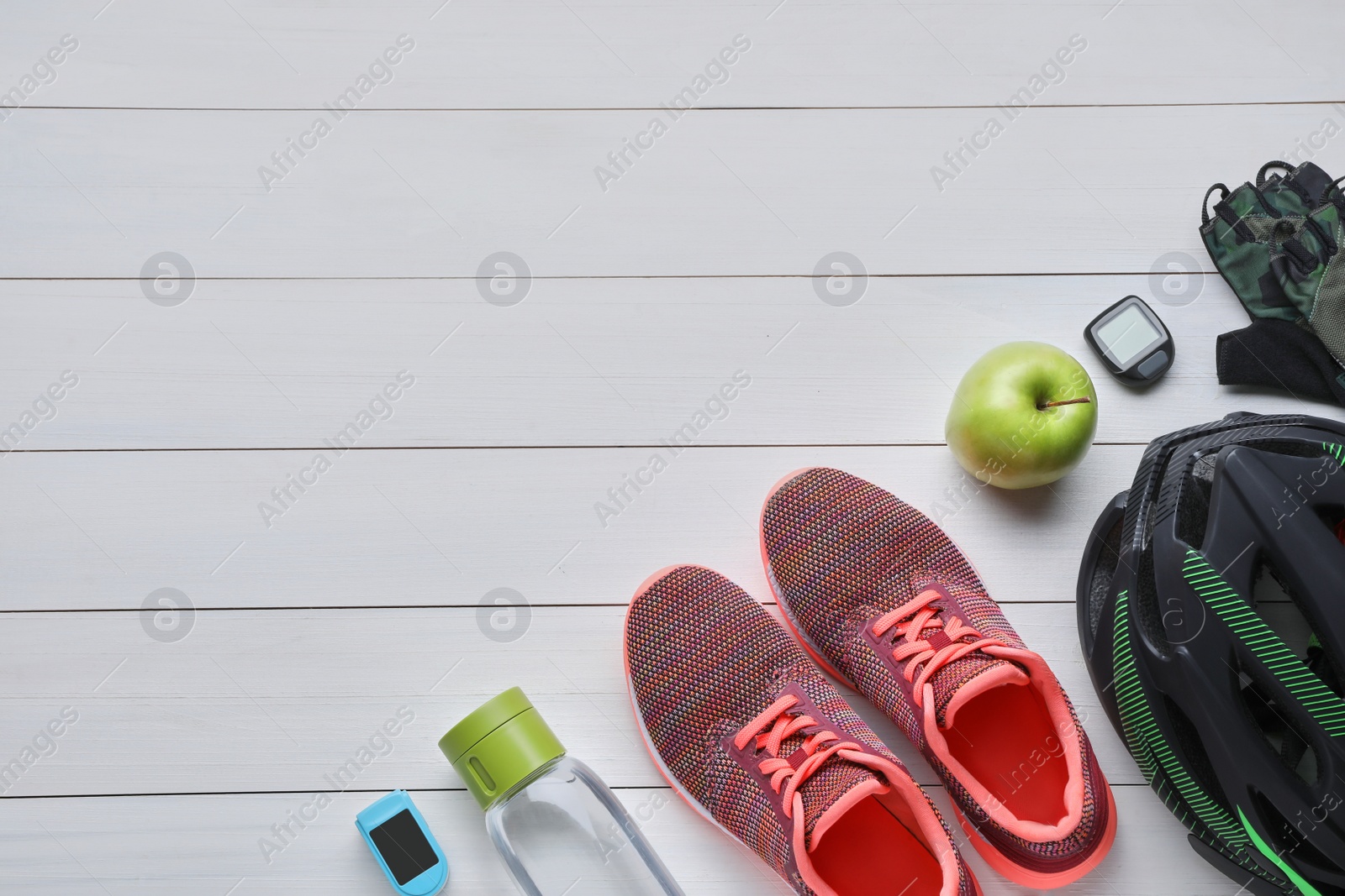 Photo of Flat lay composition with different cycling accessories on white wooden background, space for text