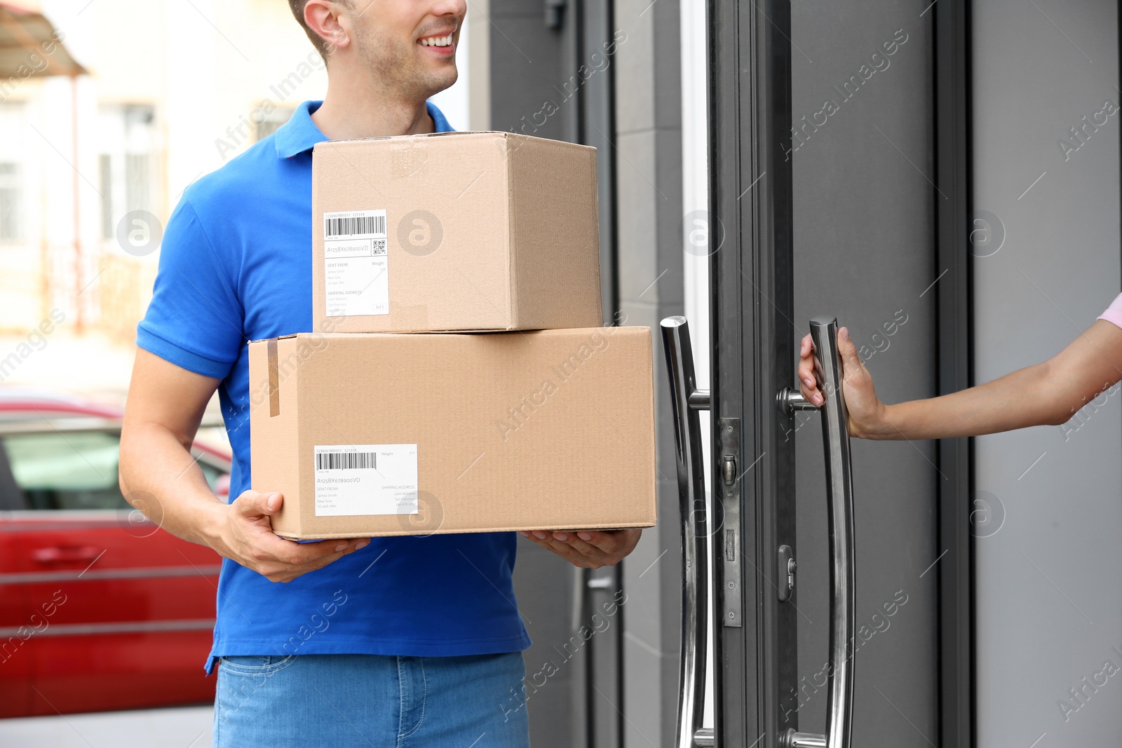 Photo of Woman opening door to delivery service courier with parcels