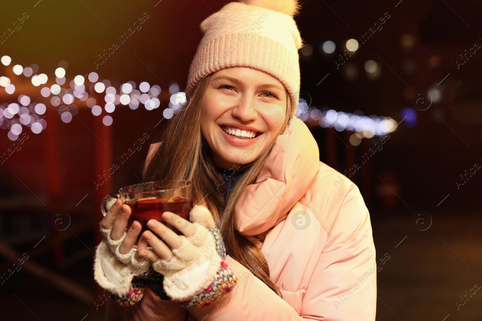 Photo of Happy woman with mulled wine at winter fair