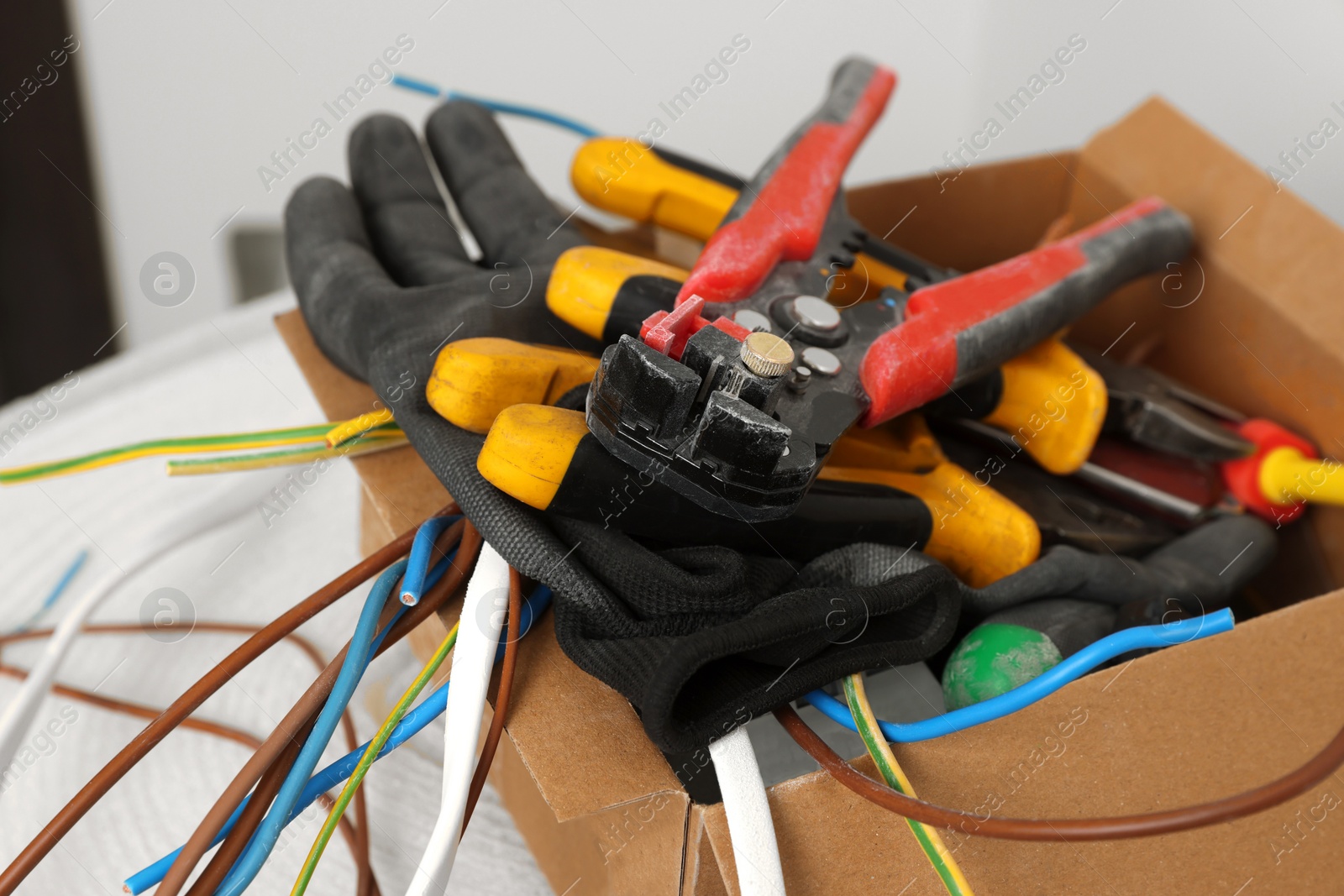 Photo of Different tools and cables in paper indoors. Installation of electrical wiring