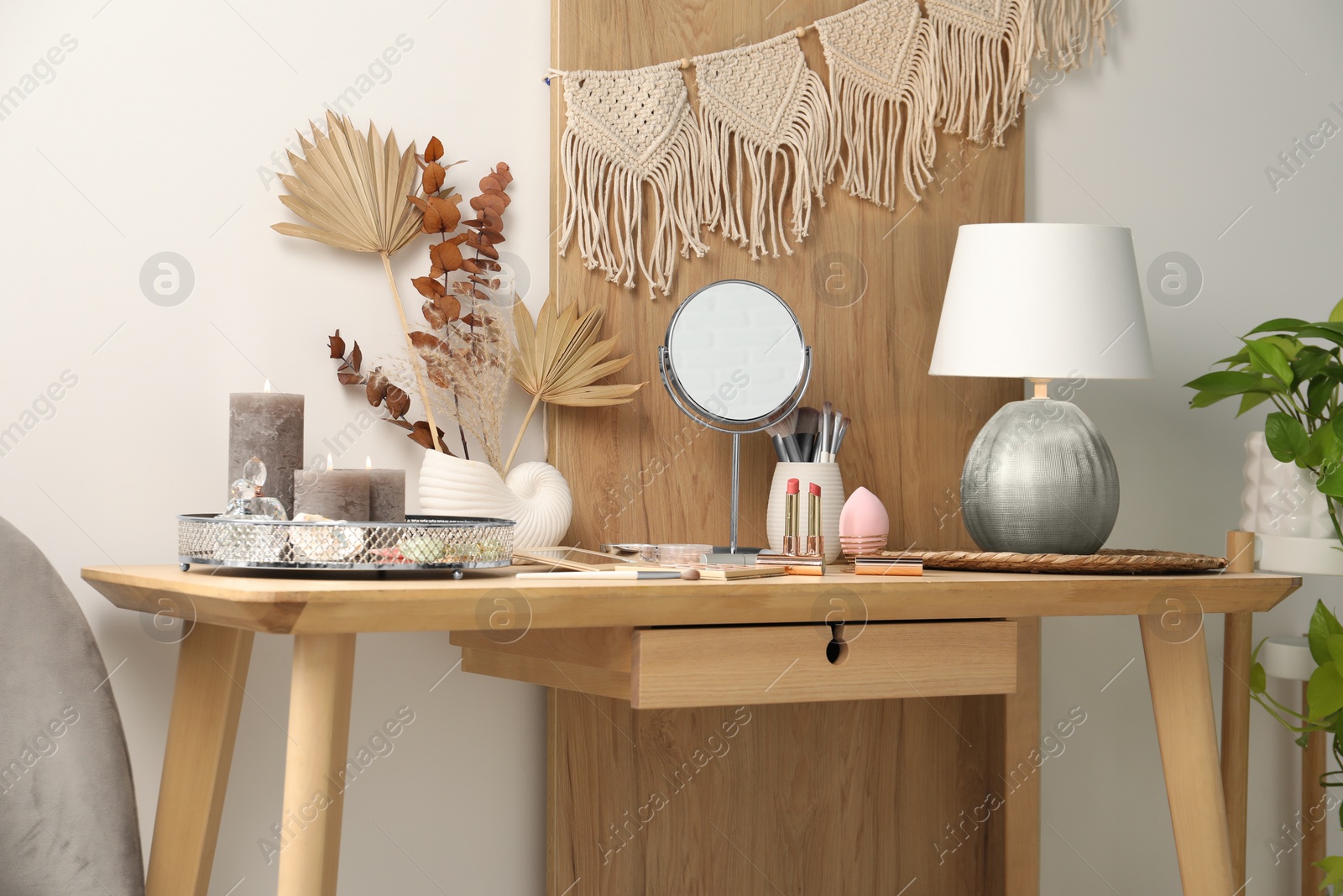 Photo of Dressing table with mirror, makeup products and decor in room