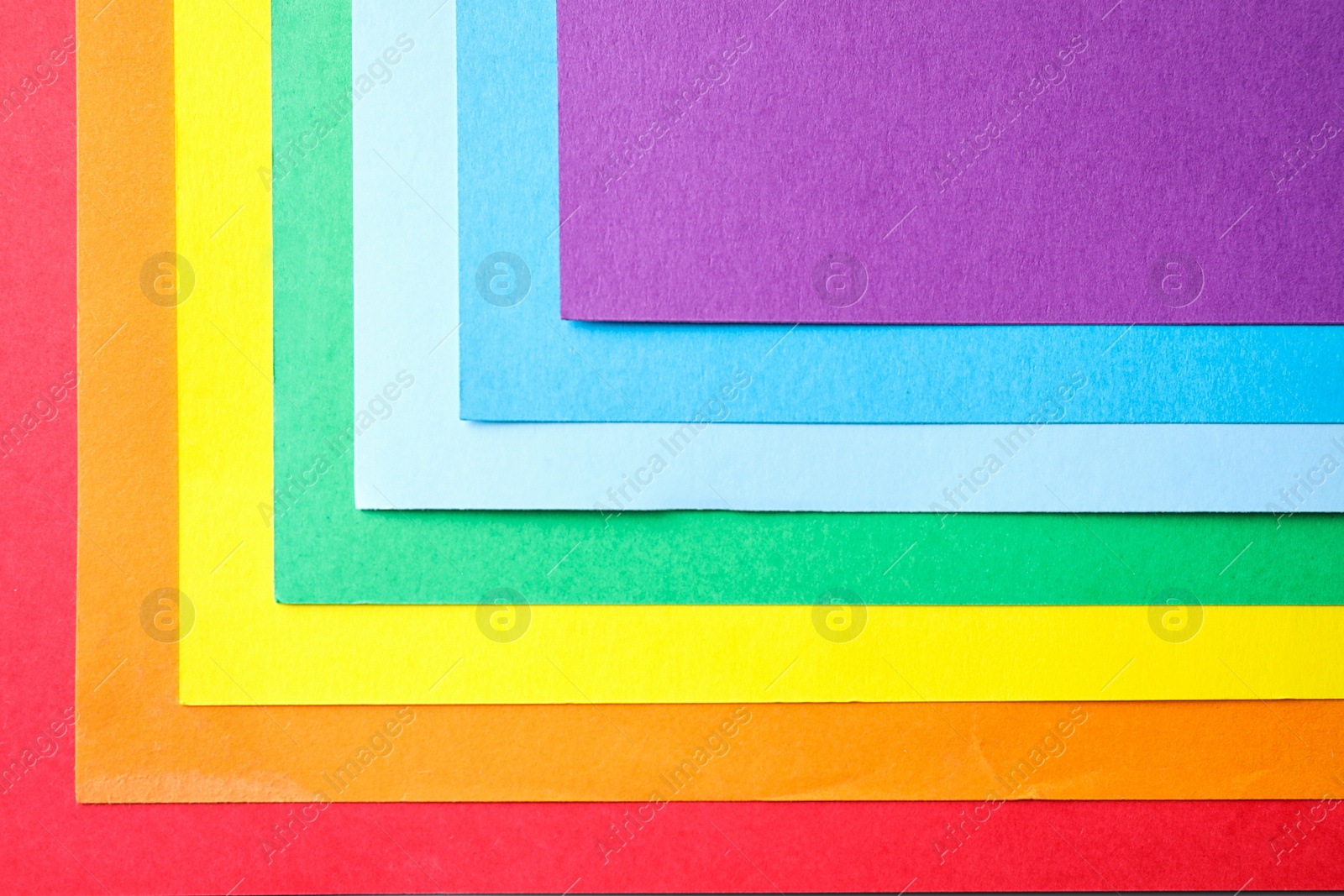 Photo of Sheets of multicolored paper, top view. Rainbow palette