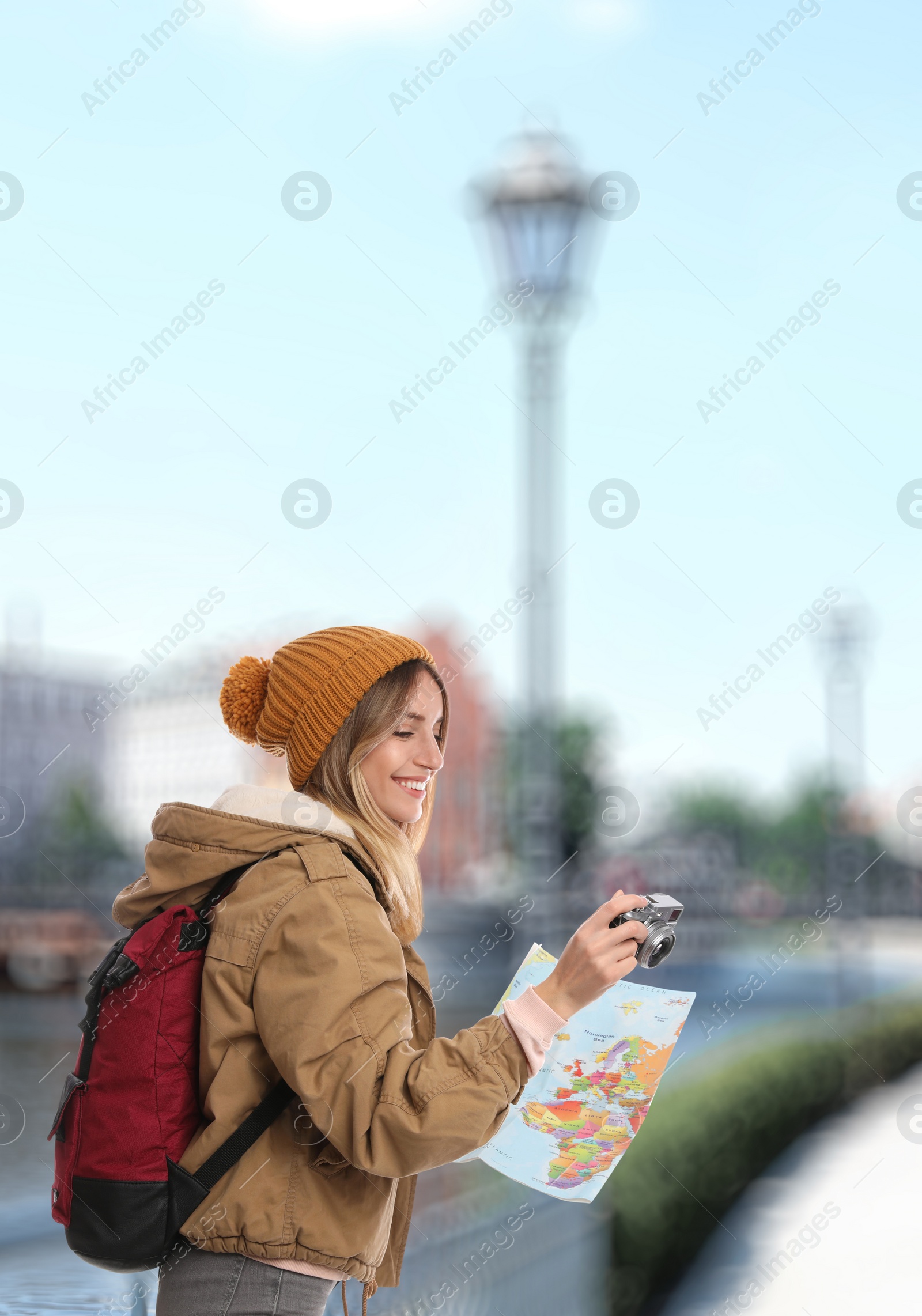 Image of Happy traveler with camera and map in foreign city. Vacation trip