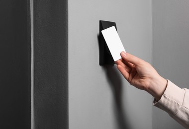 Photo of Woman opening magnetic door lock with key card, closeup. Home security