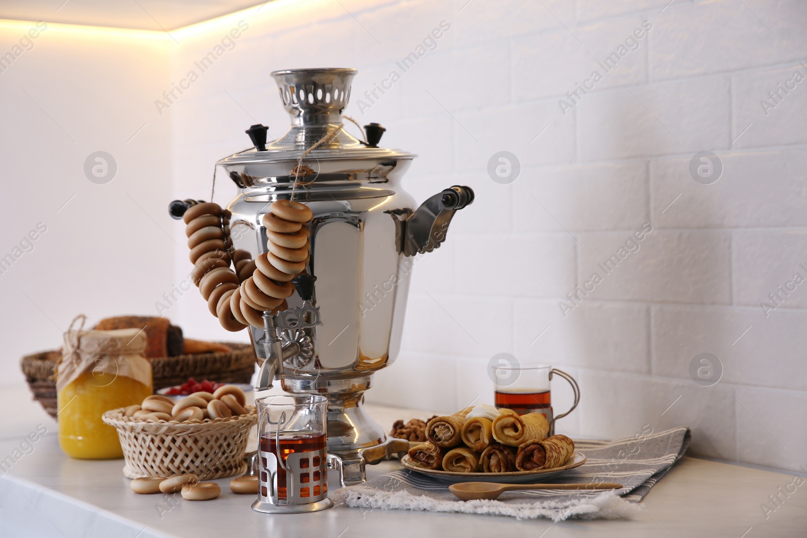 Photo of Traditional Russian samovar with treats on white table