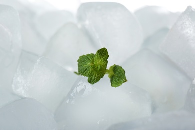 Photo of Leaves of mint on ice cubes against white background, closeup