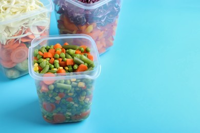 Photo of Set of plastic containers with fresh food on light blue background, space for text