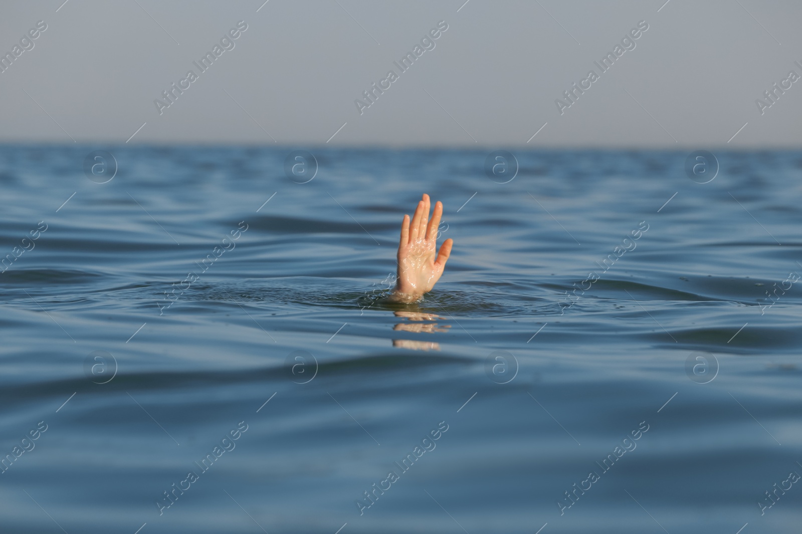 Photo of Drowning woman reaching for help in sea